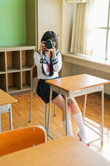 教室で写真を撮る女子高生