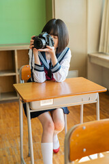 教室で写真を撮る女子高生