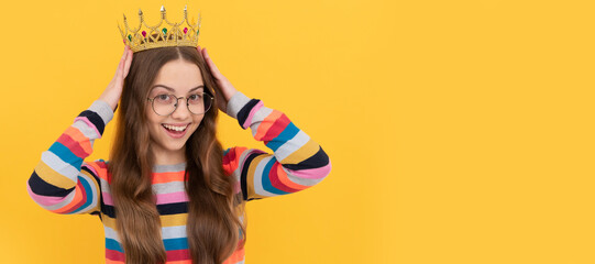 happy teen girl in glasses wear princess crown on yellow background, prom. Child queen princess in...