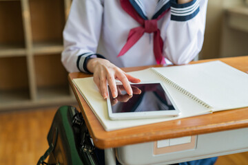 授業中にタブレット端末を使う女子高生