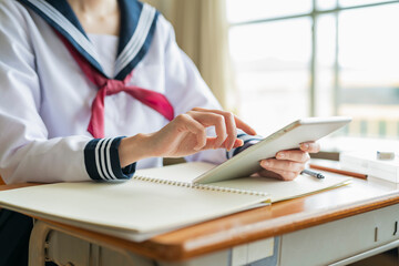 授業中にタブレット端末を使う女子高生