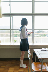 教室 窓の外を見る女子高生