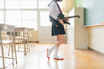 教室でギターを弾く女子高生