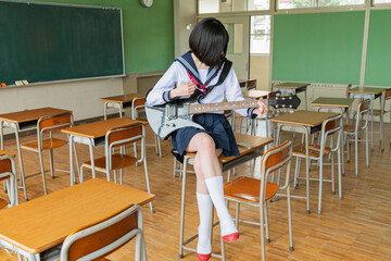 教室でギターを弾く女子高生