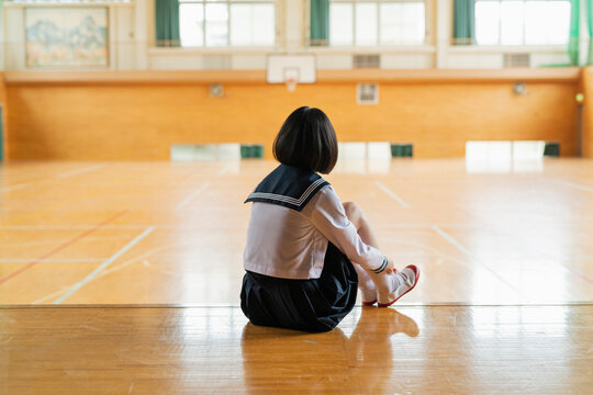 体育館 ステージに座る女子高生