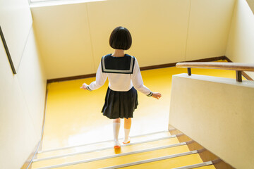 学校 階段をかけ降りる女子高生