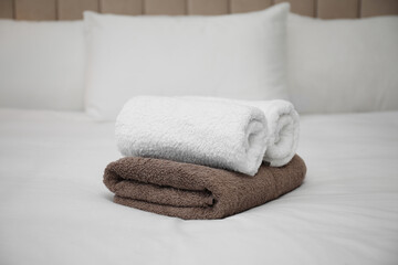 Fototapeta na wymiar Soft clean terry towels on white bed