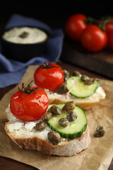 Tasty bruschettas with vegetables and capers on table, closeup