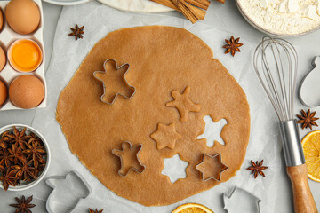 Flat lay composition with dough and cookie cutters on light table