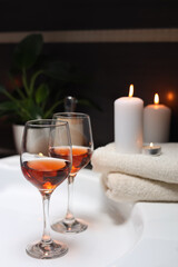 Bathtub with glasses of wine and candles indoors. Romantic atmosphere