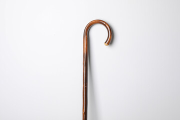 Elegant wooden walking cane on white background
