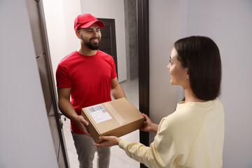Woman receiving parcel from courier at home