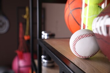 Different sport balls on shelf indoors, closeup. Space for text