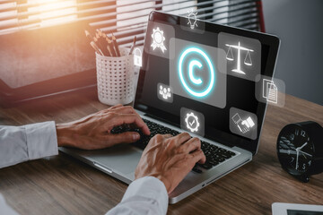 Copyright or patent concept, Person hand using laptop computer on desk with VR screen copyright icon background, Copyleft trademark license, Creation ownership against piracy crime. - obrazy, fototapety, plakaty
