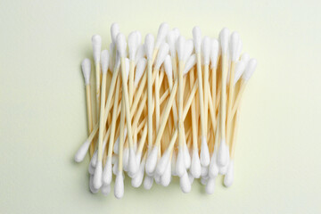 Heap of cotton buds on beige background, top view