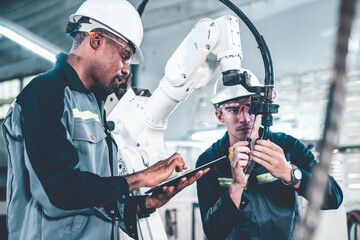 Ouvriers d& 39 usine travaillant avec un bras robotique adepte dans un atelier . Logiciel de programmation de robots industriels pour la technologie de fabrication automatisée .