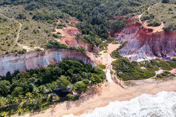 Vista aérea feita com drone da uma linda praia do litoral brasileiro, com as falésias, montanhas,...