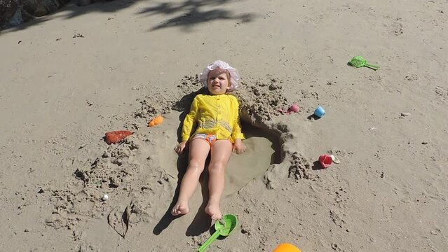 Child playing with fun on the beach with toys. Summer time outdoors. Family beach vacation
