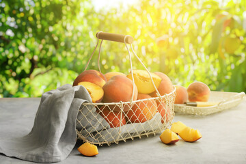 Basket with ripe peaches on table in garden