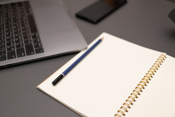 Gray desk office with laptop, smartphone and other work supplies. computer desk with keyboard, smartphone and stationery. copy space for input the text.