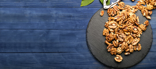 Composition with tasty walnuts on blue wooden background with space for text, top view