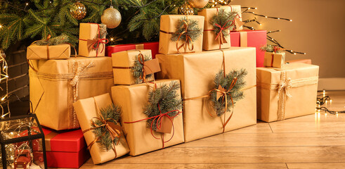 Many gift boxes under Christmas tree in living room in evening