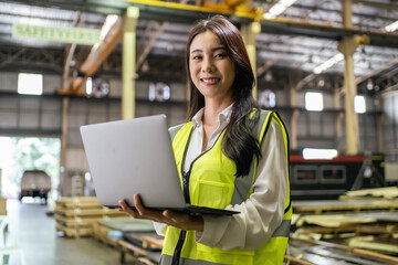 Portrait of Asian female industry worker working in factory warehouse. 