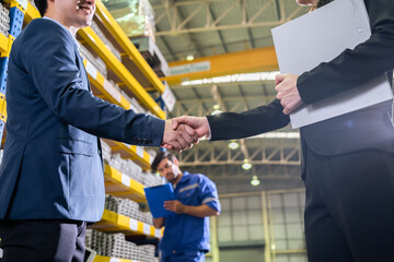Asian businessman and woman handshake after negotiation in manufactory