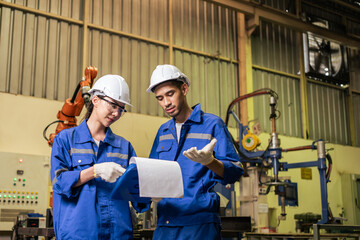 Asian male and female industrial worker working in manufacturing plant