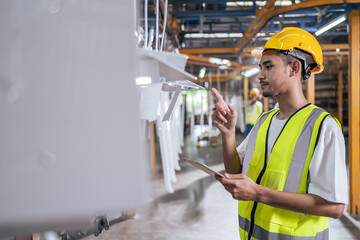 Asian attractive man industrial worker working in manufacturing plant.