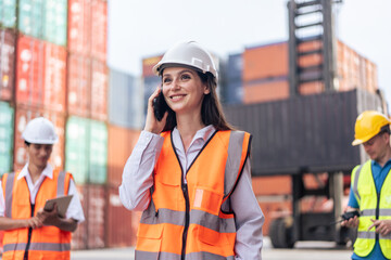 Caucasian businesswoman talk on phone while work in container terminal