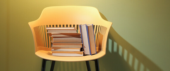 Chair with books near color wall