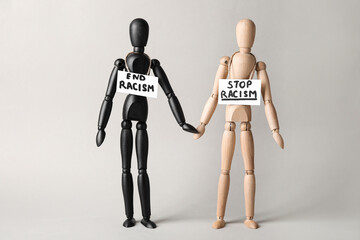 Wooden mannequins on grey background. Concept of racism