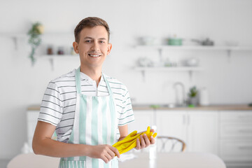 Young man with rubber gloves in kitchen