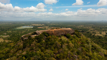 Aerial view of Pidurangala rock among the dense forest on the island of Sri Lanka. Tropical green forest and jungle.