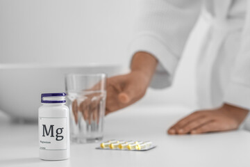 Bottle of magnesium pills on table in bathroom, closeup