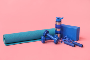 Set of modern sports equipment on pink background