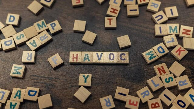 Word play. Square colorful wooden letters creating the word HAVOC. Destruction and demage concept as a symbol. High quality 4k footage