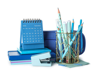 Cup with school stationery, pencil case and calendar on white background