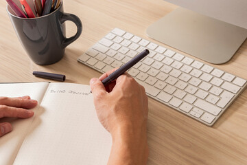 Man's hands writing in a notebook