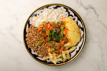 Roast beef and vegetables with different garnish top view on uzbek plate