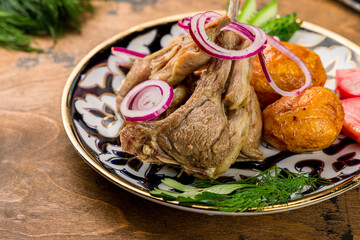 Kazan kebab on plate with red onion and fried potatoes macro close up