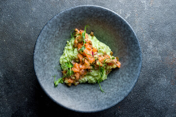 risotto with seafood, sliced salmon on grey table