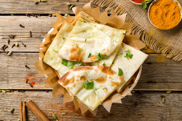bread tandoori with cheese and greenery, indian cuisine on old wooden tables with spices top view