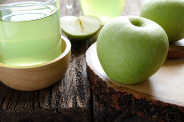 Fresh apple juice and green apple on the wooden table. Healthy drink concept. Selective focus