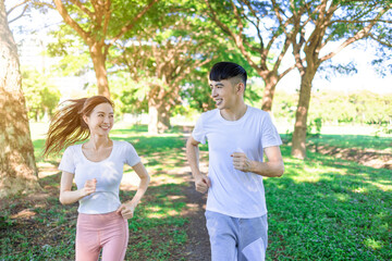 Happy young couple jogging in the  park on sunny day