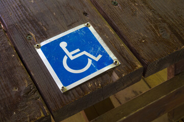 handicap sign wheelchair accessibility metal blue pictogram on wood