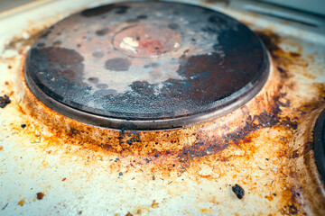 Old kitchen electric stove in heavy brown pollution and soot close up