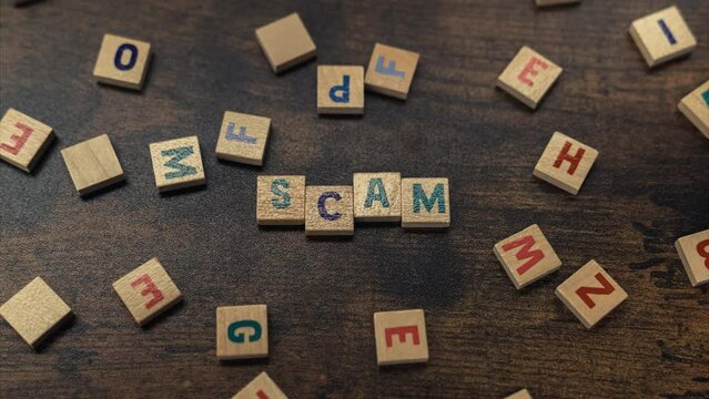 SCAM - scattered square colourful letter puzzles creating a word. The danger of being scammed and tricked by criminals. High quality 4k footage
