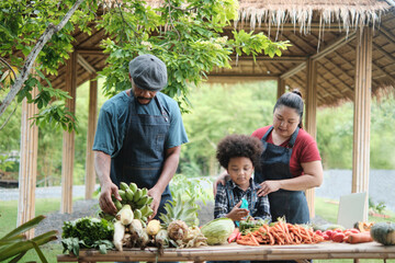 Happy diversity farmer family, Black dad and Asian mum with son in apron sell natural products from...